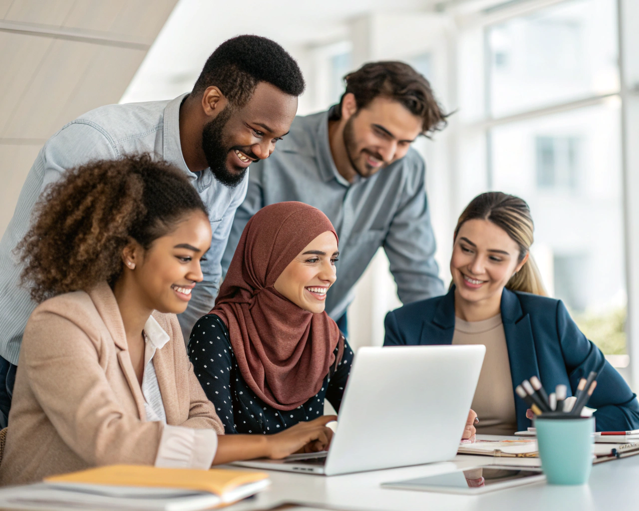 Grupo diverso de personas colaborando en un moderno espacio de trabajo, simbolizando inclusión y unidad en un ambiente luminoso y acogedor.